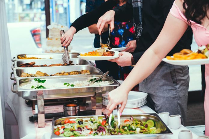 Picking up food with utensils from the buffet trays Global EAT - Norovirus Outbreaks on Cruise Ships Have Doubled Compared to Last Year